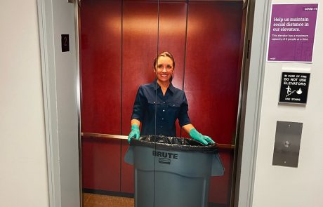 Indoor acrylic signage that looks like an open elevator with a young lady working a cleaning service