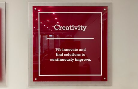 Acrylic Indoor Signage Maroon background white letters reading Creativity, We innovate and find solutions to continuously improve.