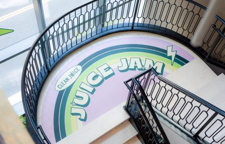 Indoor floor decal sign, half way up a set of stairs. Rainbow with shades of green, Clean Juice, Juice Jam