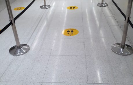 Floor decals and graphics for common places. AIrport security line with yellow circles and black footprints on the ground.