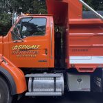Orange Dump Truck with Vehicle graphics on driver side door. Asphalt Services 704-920-9842